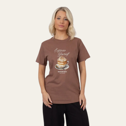 Woman wearing a brown t-shirt with a coffee graphic and text on a beige background