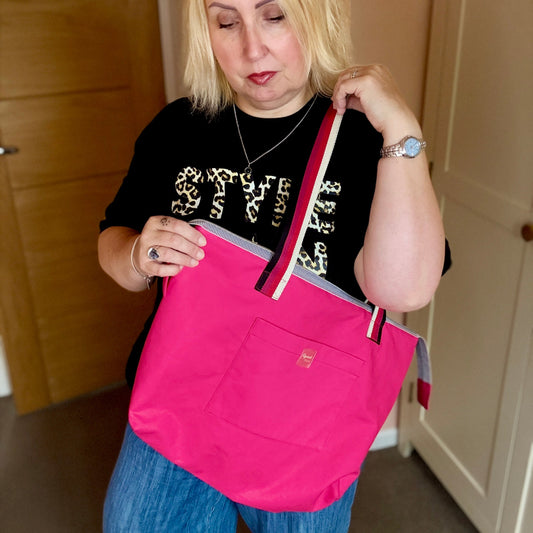 Woman holding a pink tote bag indoors