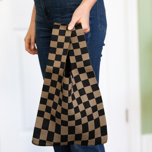 Person holding a checkered bag with a blurred background