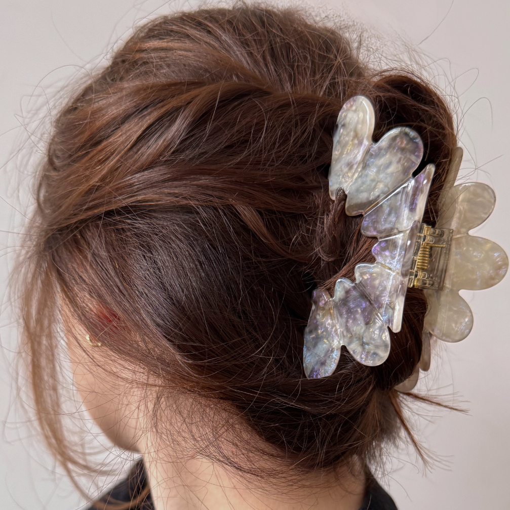 Person with decorative hair clips in their bun against a neutral background