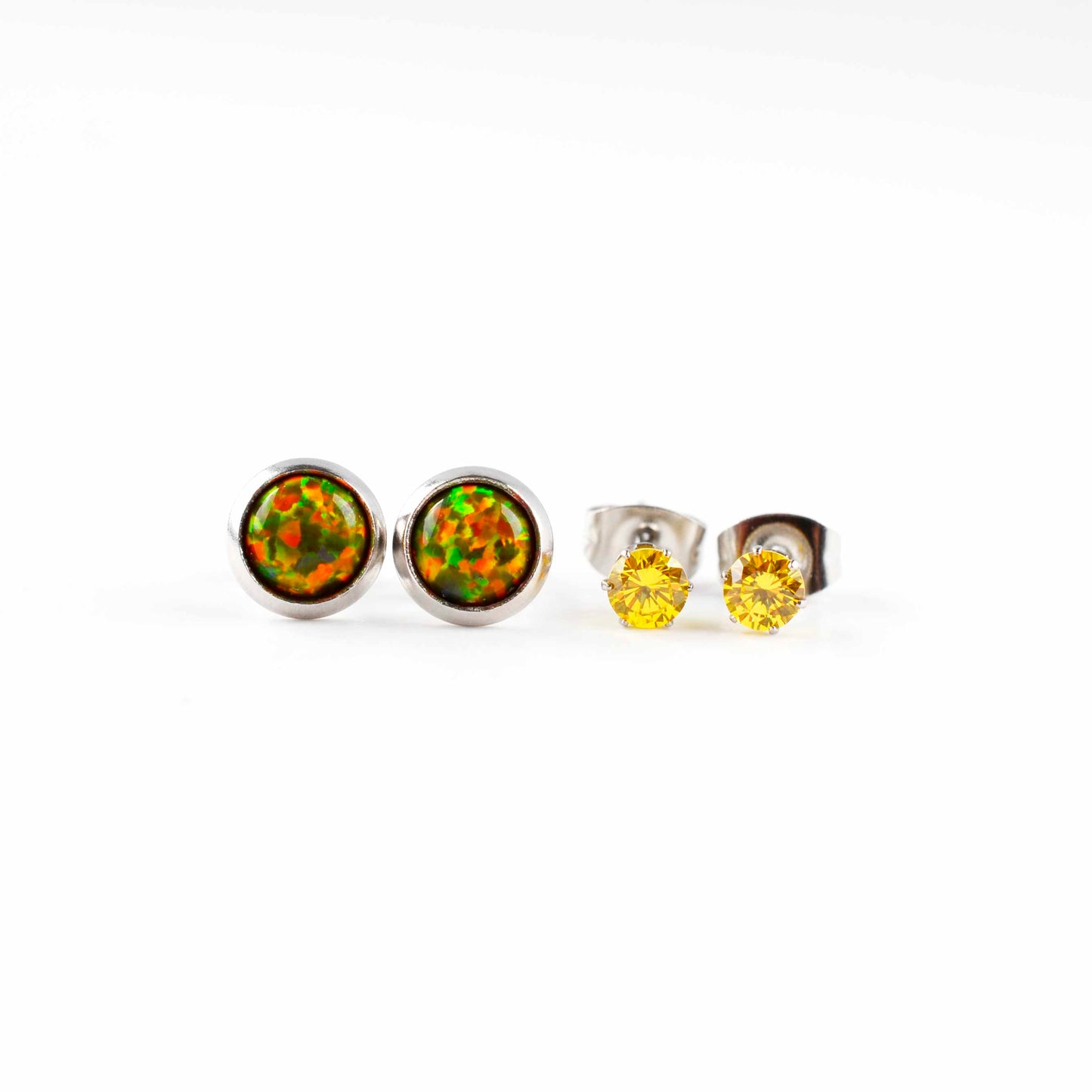 Front view of olive green opal studs and yellow CZ stud earrings on a white background.