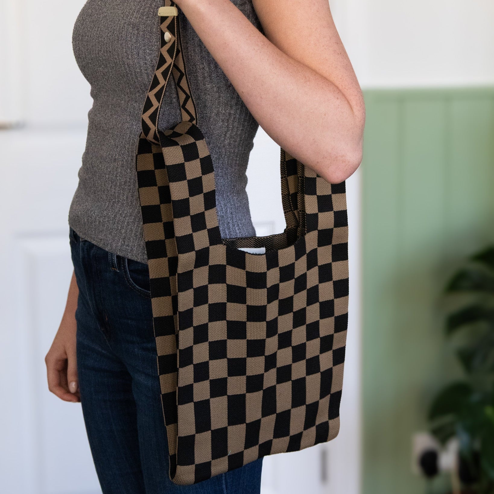 Person holding a checkered bag with a blurred background