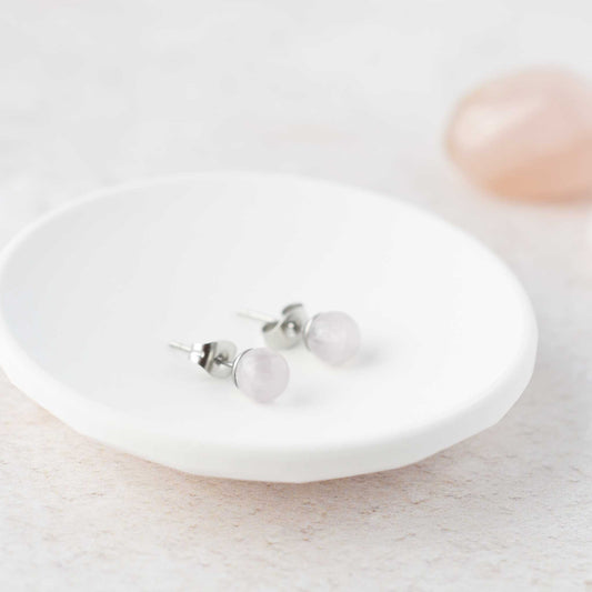 Rose Quartz gemstone ball stud earrings laying in white trinket dish.