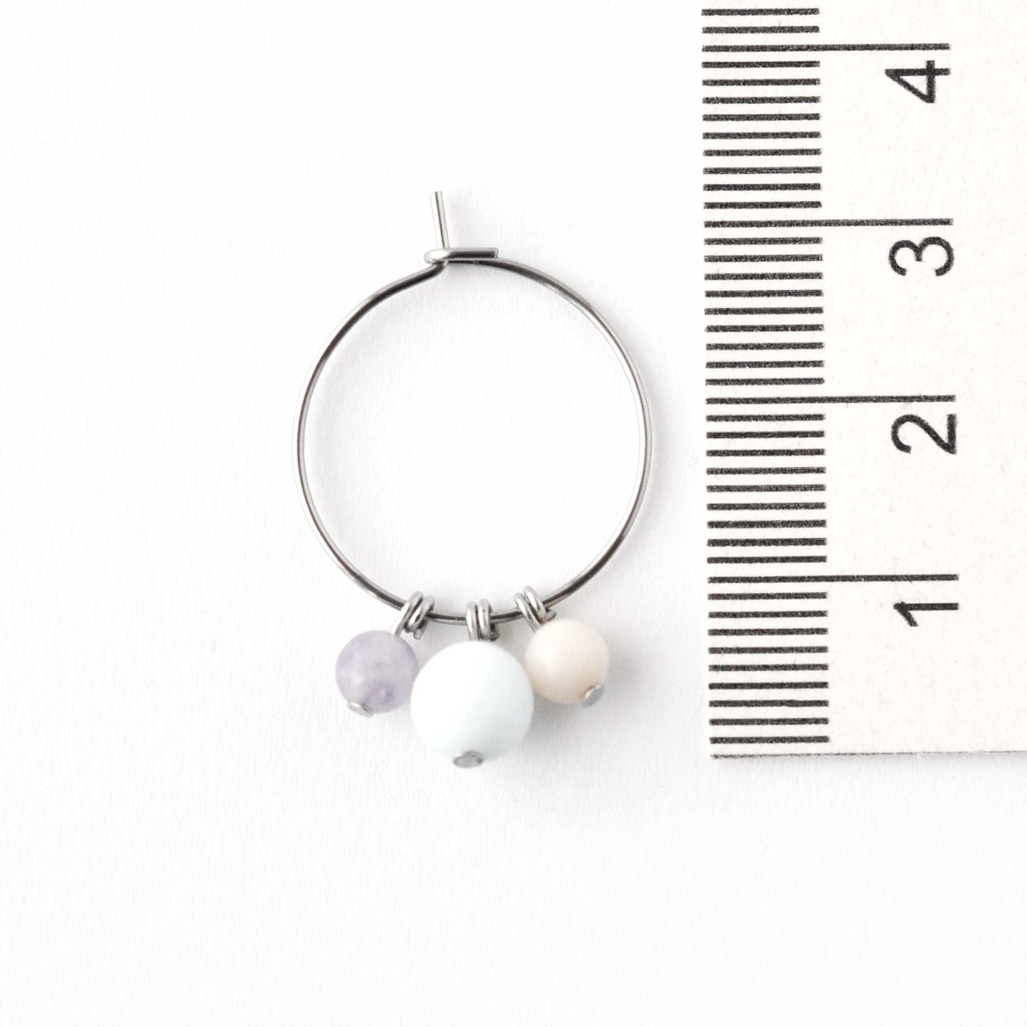 2cm diameter surgical steel hoop earring with pastel gemstone beads next to ruler