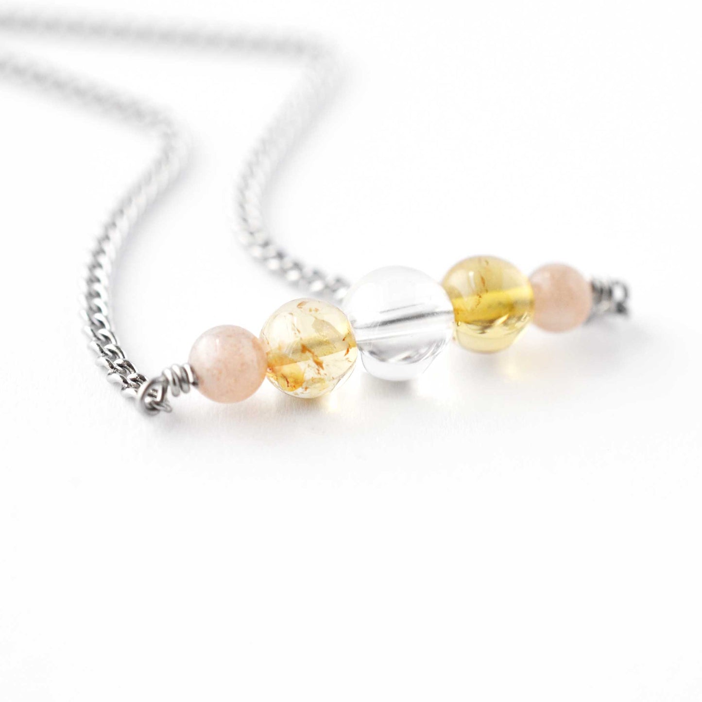 Close up of Sunstone, Citrine & Rock Crystal gemstones on stainless steel chain
