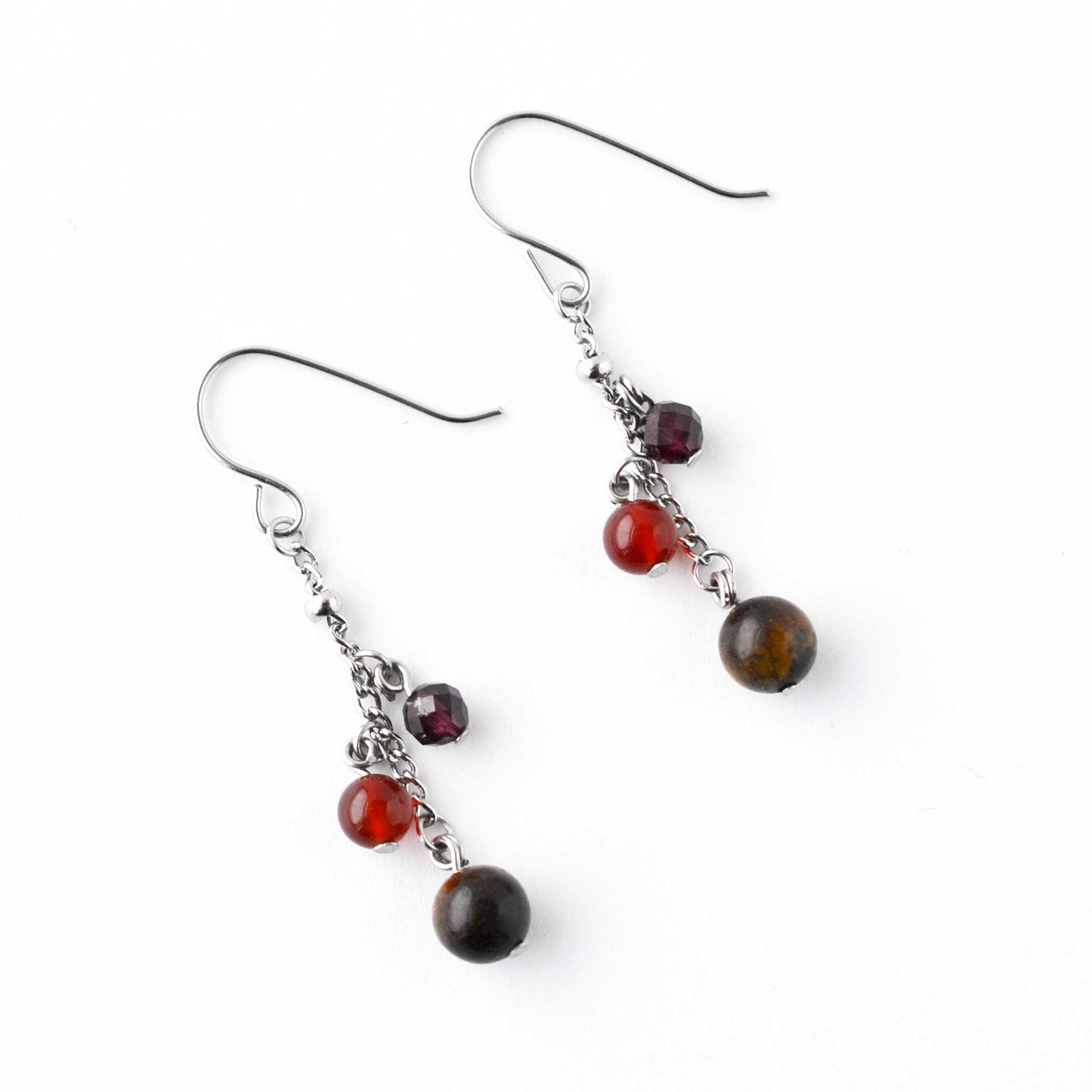 Flatlay Tigers Eye, Carnelian & Garnet gemstone drop earrings on white background