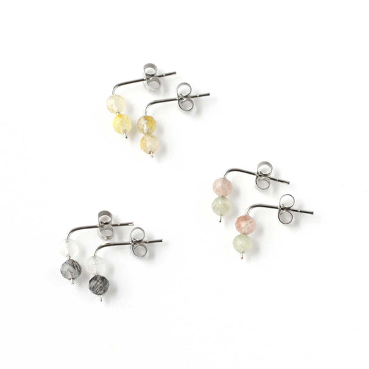 Three pairs of multicoloured Quartz gemstone stud earrings on white background