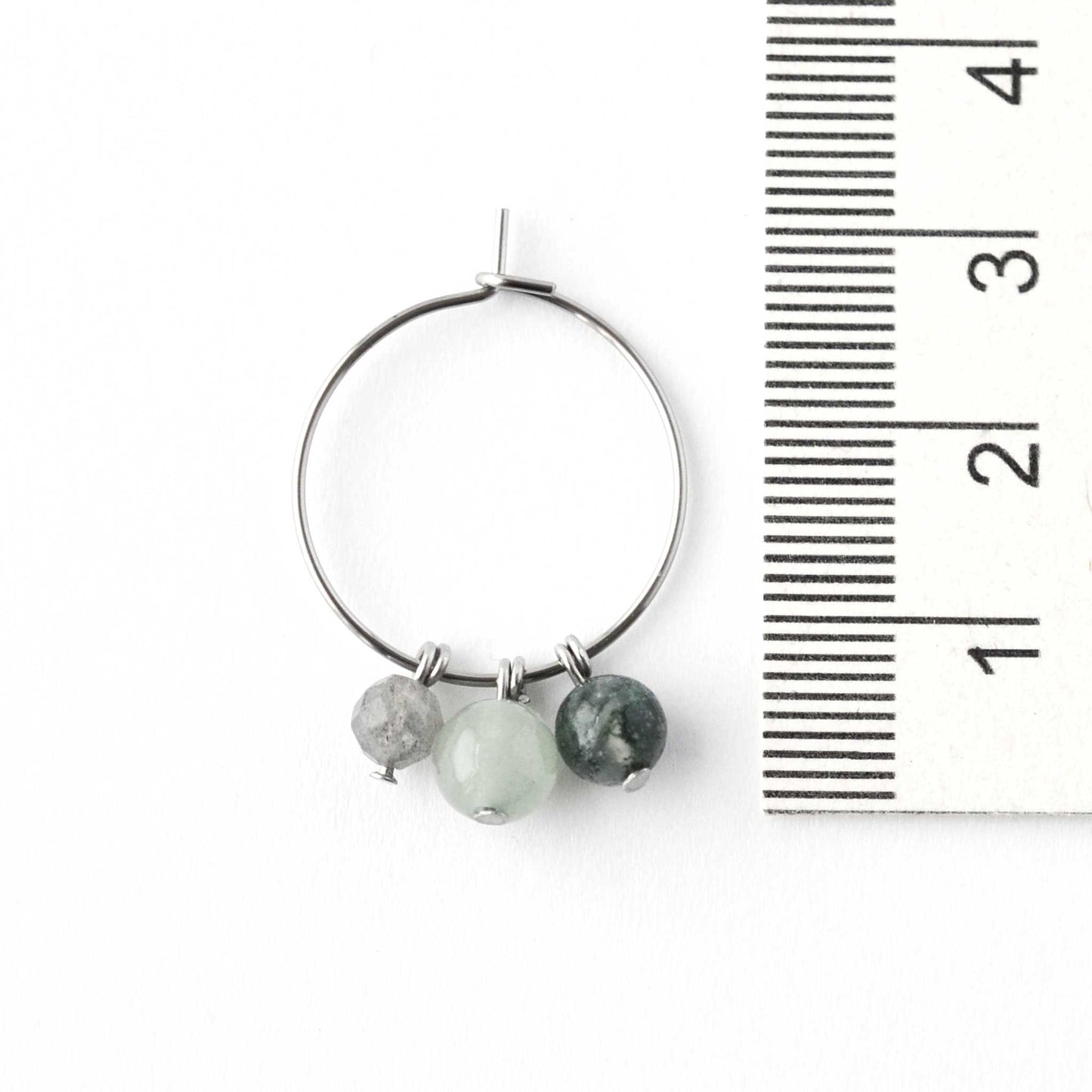 2cm diameter hypoallergenic hoop earring with green gemstone beads next to ruler