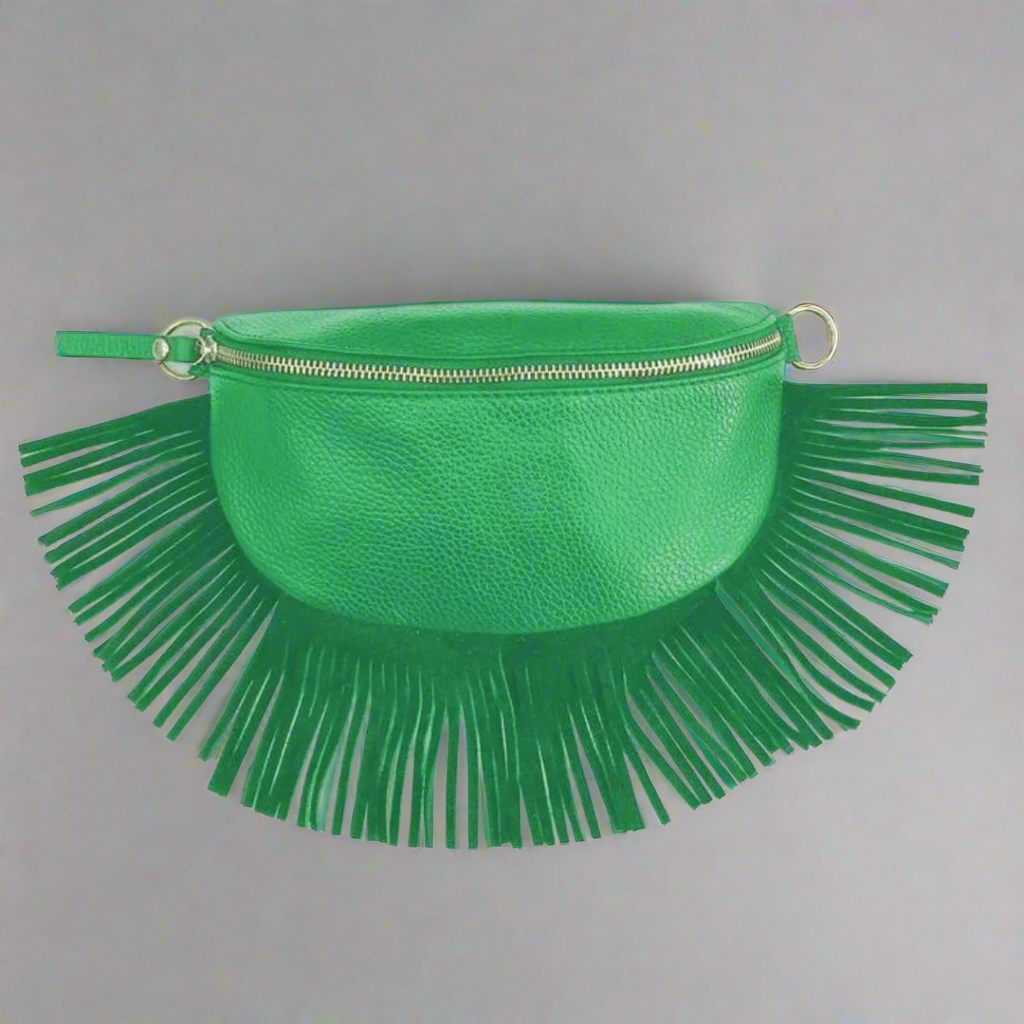 Green clutch bag with fringe details on a gray background