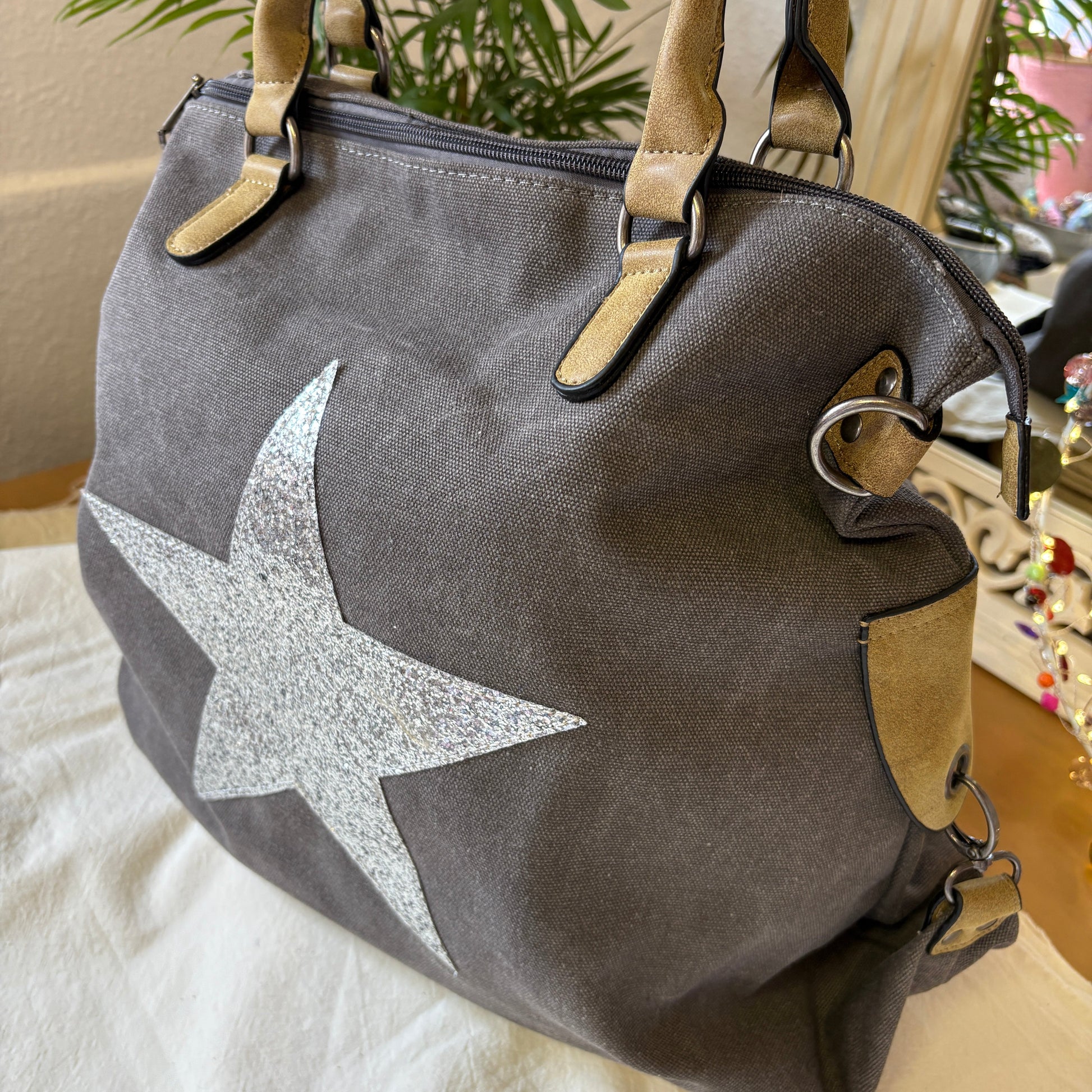 Gray handbag with a star design on a light surface