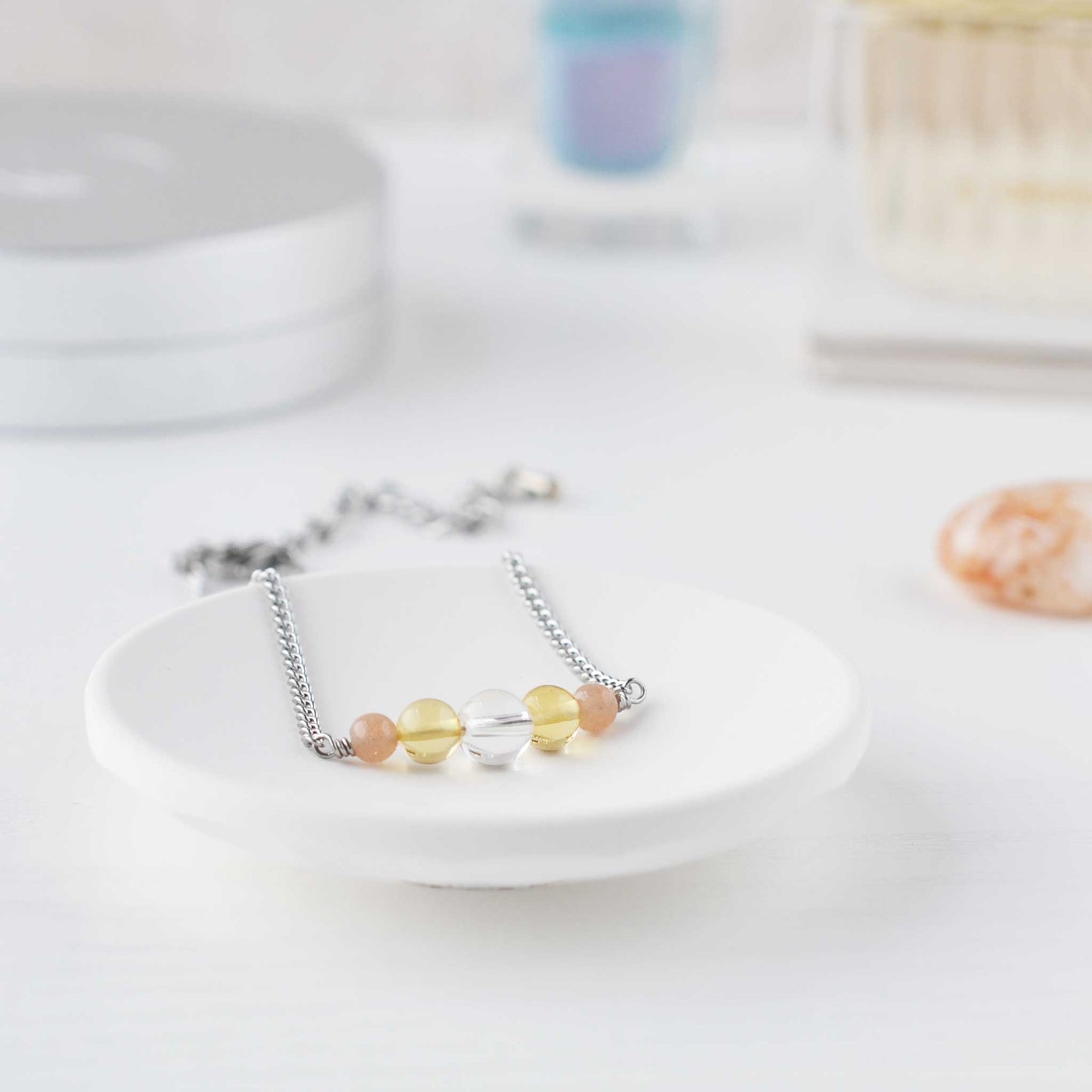 Dainty yellow gemstone bracelet in trinket dish on dressing table