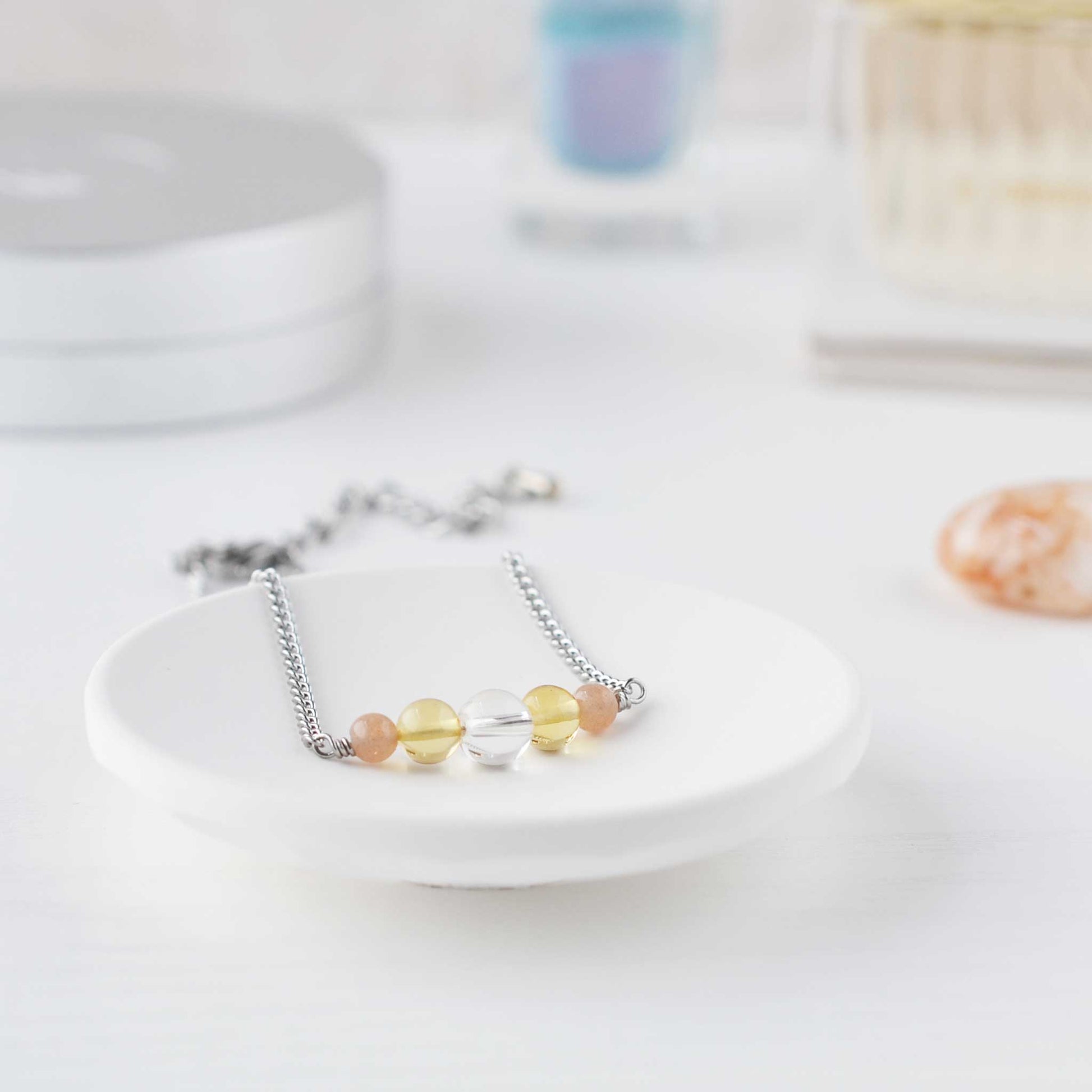 Dainty yellow gemstone bracelet in trinket dish on dressing table