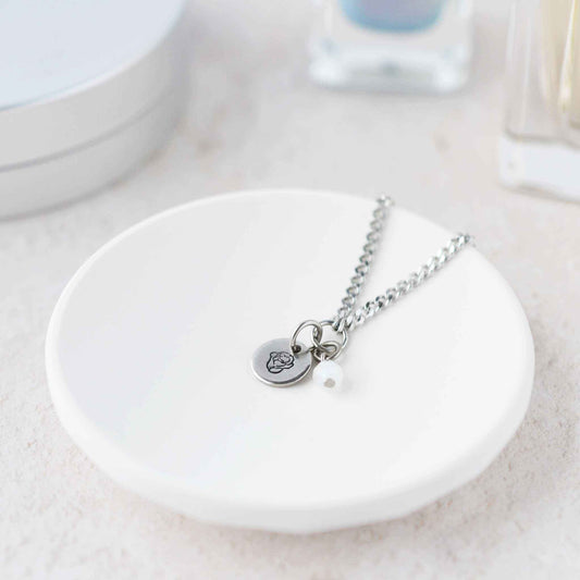 Tiny Rose & Moonstone gemstone necklace laying in white trinket dish