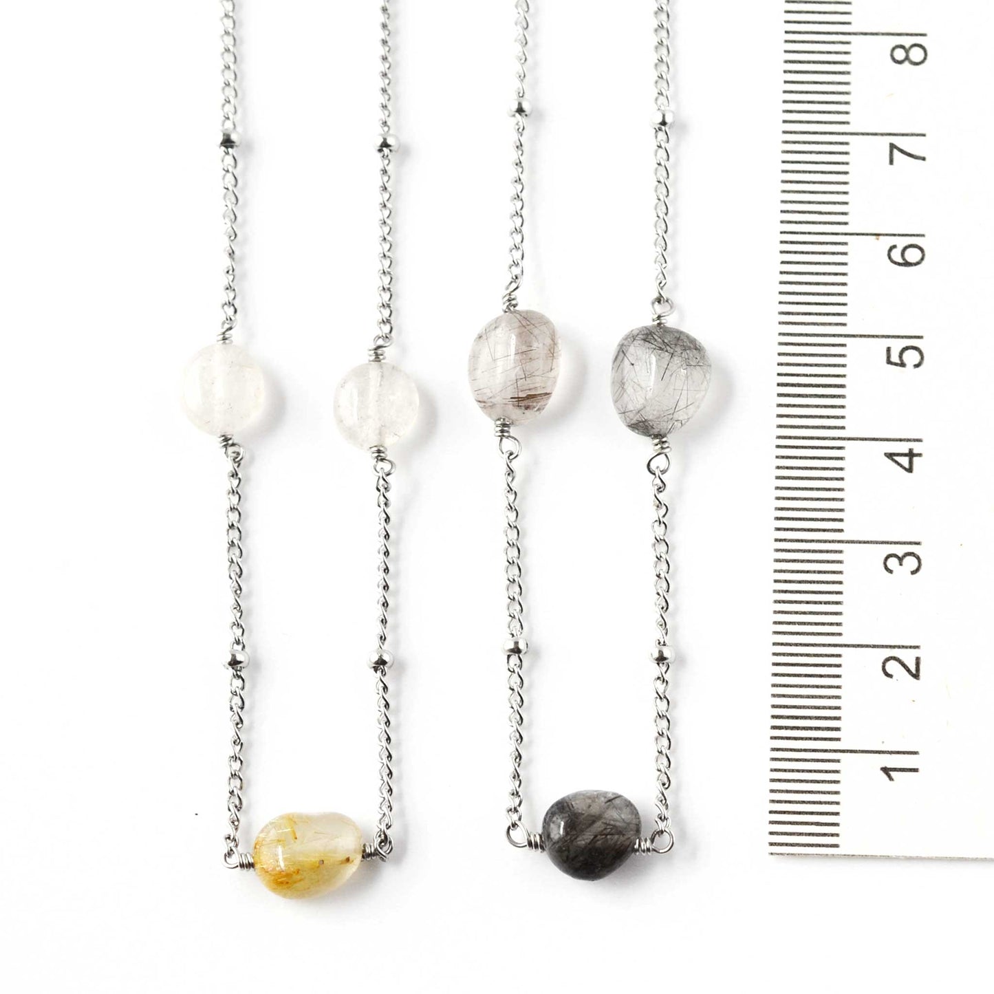 Two gemstone necklaces next to ruler