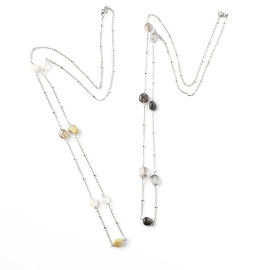 Two long Quartz gemstone necklaces lying on white background
