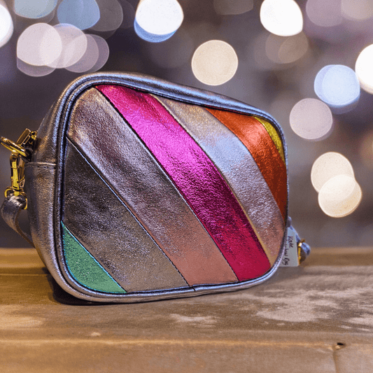 Multicolored striped bag on a wooden surface with blurred lights in the background