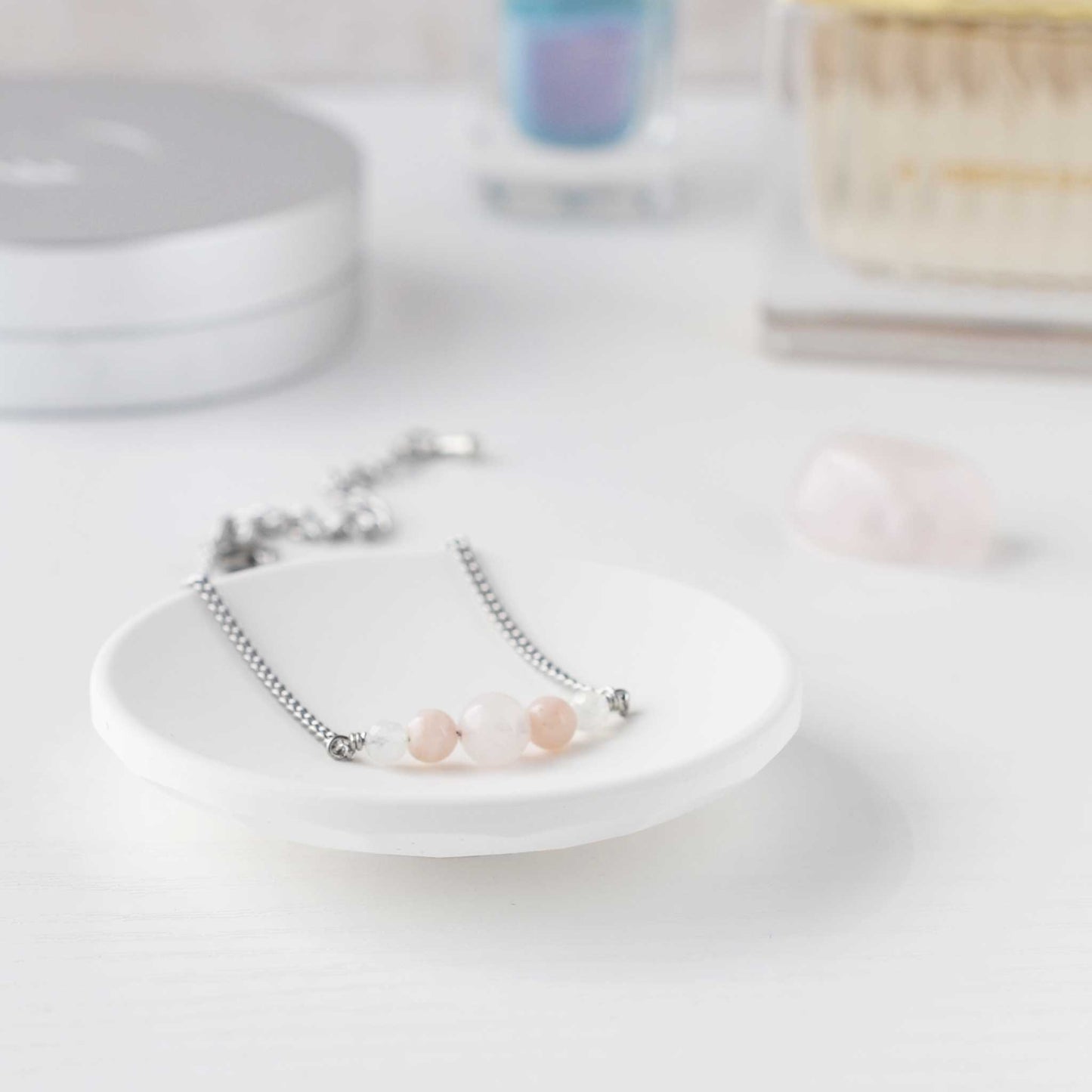 Dainty pale pink bracelet in trinket dish on dressing table