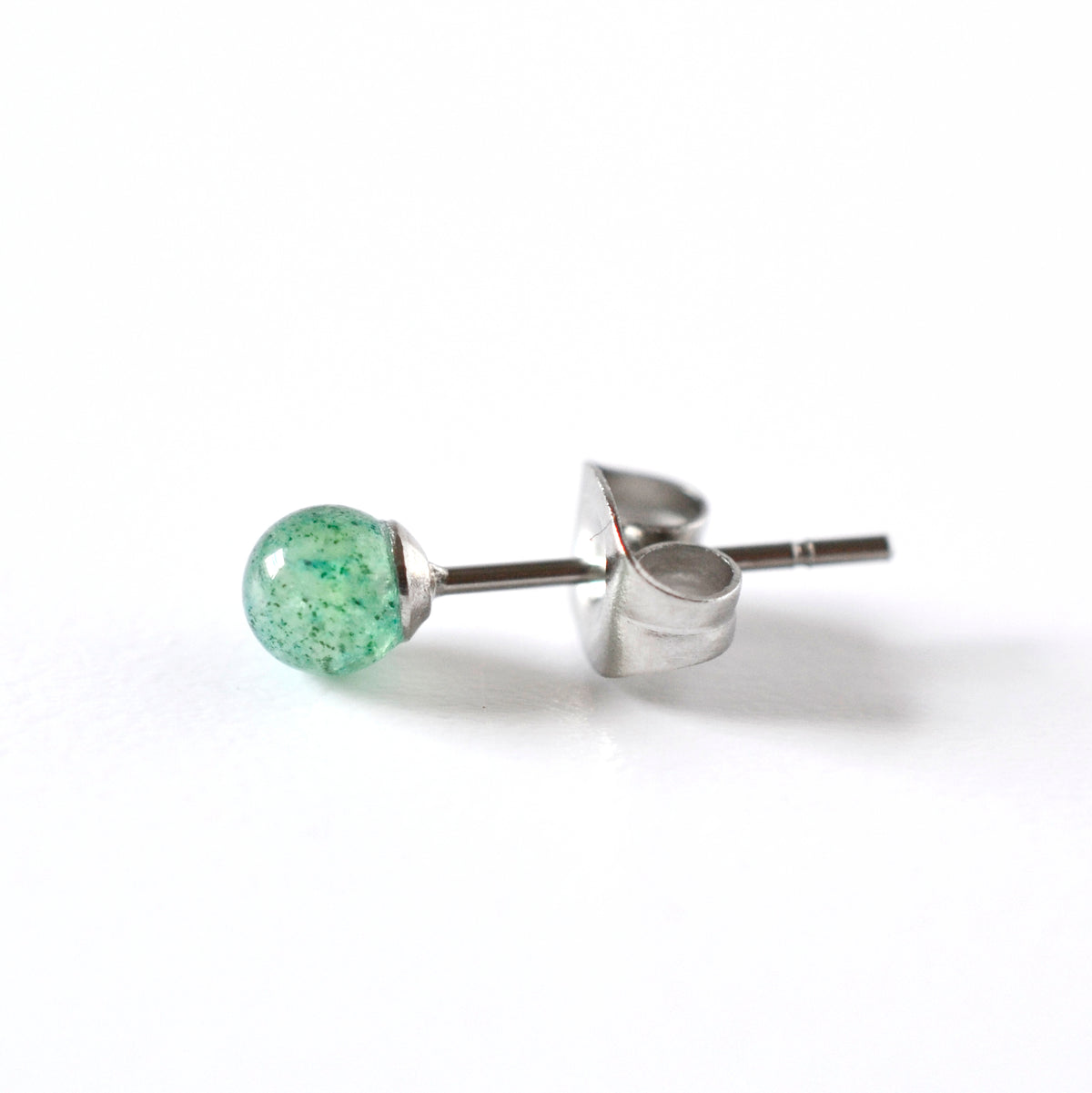 A single surgical steel stud earring with a small, round, green aventurine gemstone, shown on a plain white background.