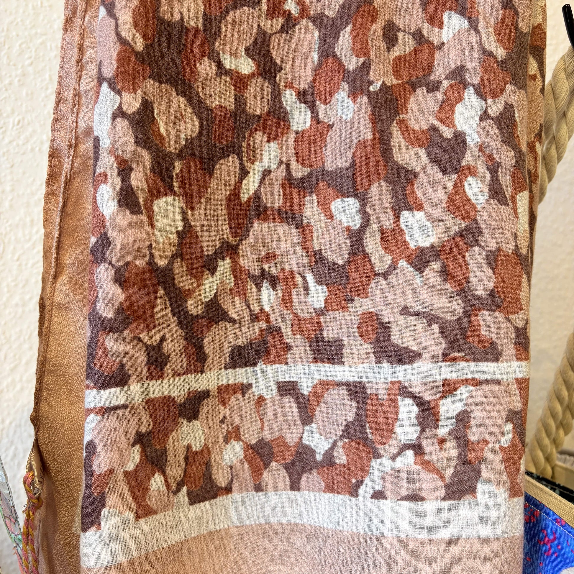 Camouflage-patterned fabric with a neutral color scheme on a textured background