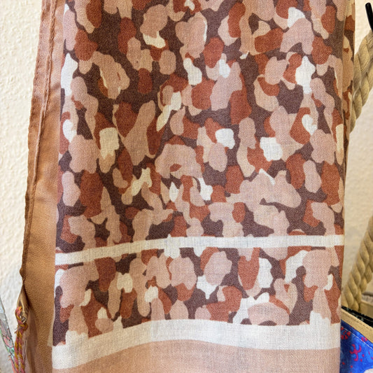 Camouflage-patterned fabric with a neutral color scheme on a textured background