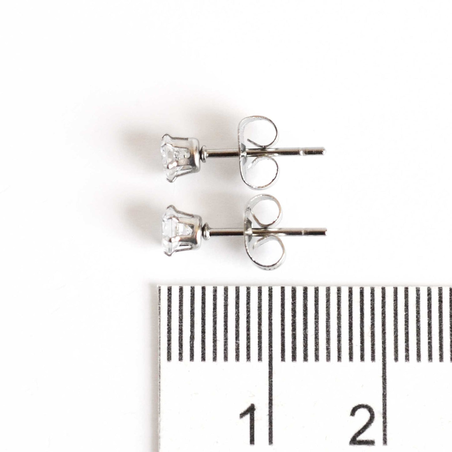 4mm Cubic Zirconia stud earrings next to ruler