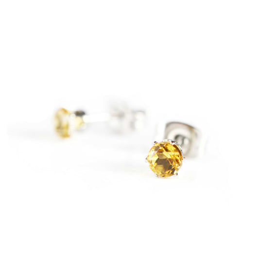 Tiny yellow Citrine stud earrings on white background
