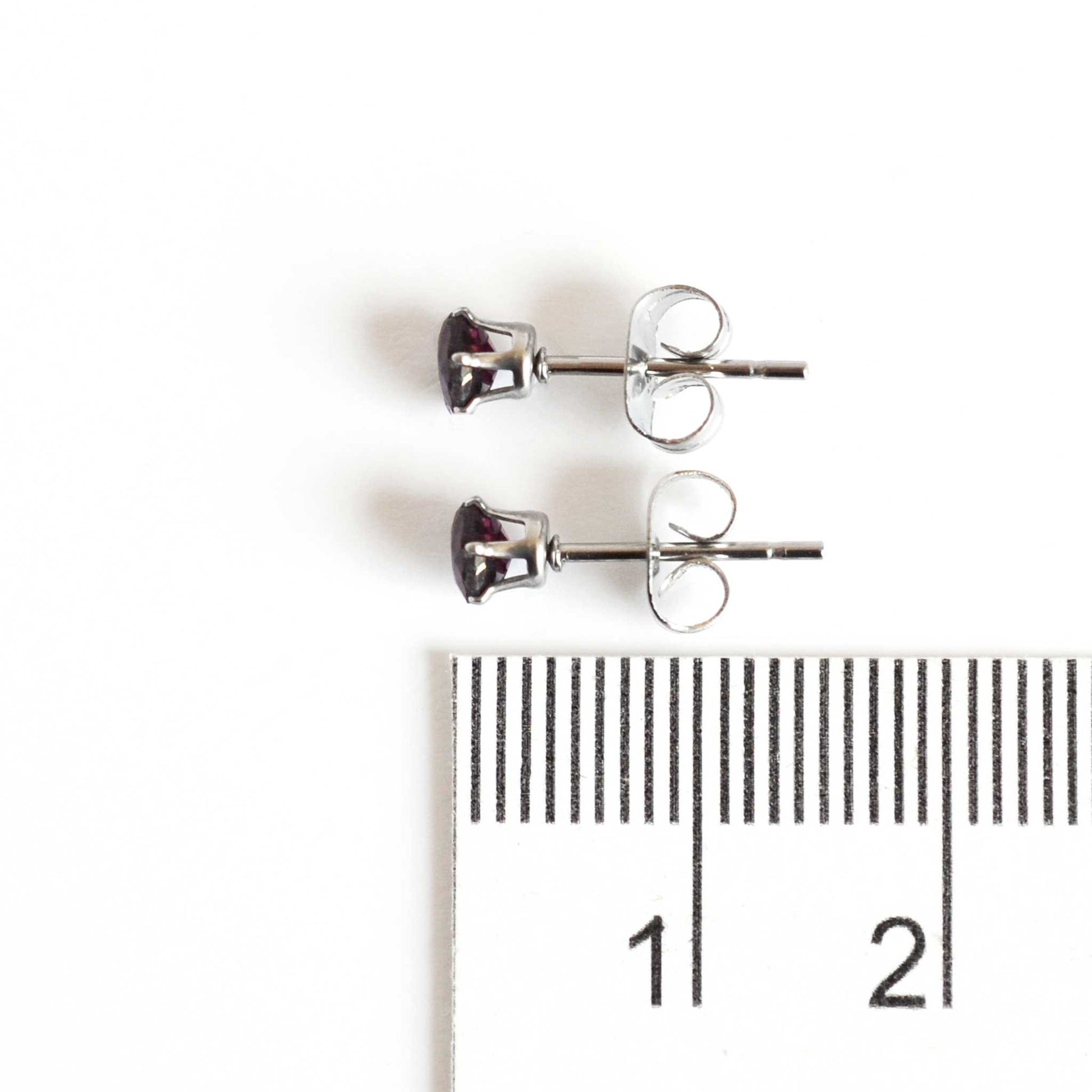 4mm Garnet stud earrings next to ruler