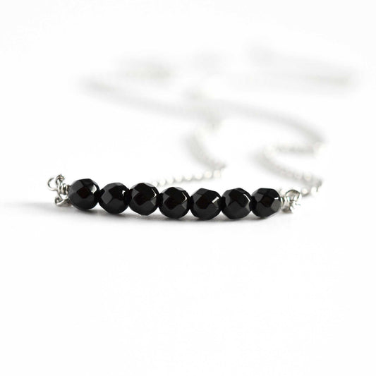 Close up of Onyx bar necklace with seven small round faceted black Onyx gemstone beads