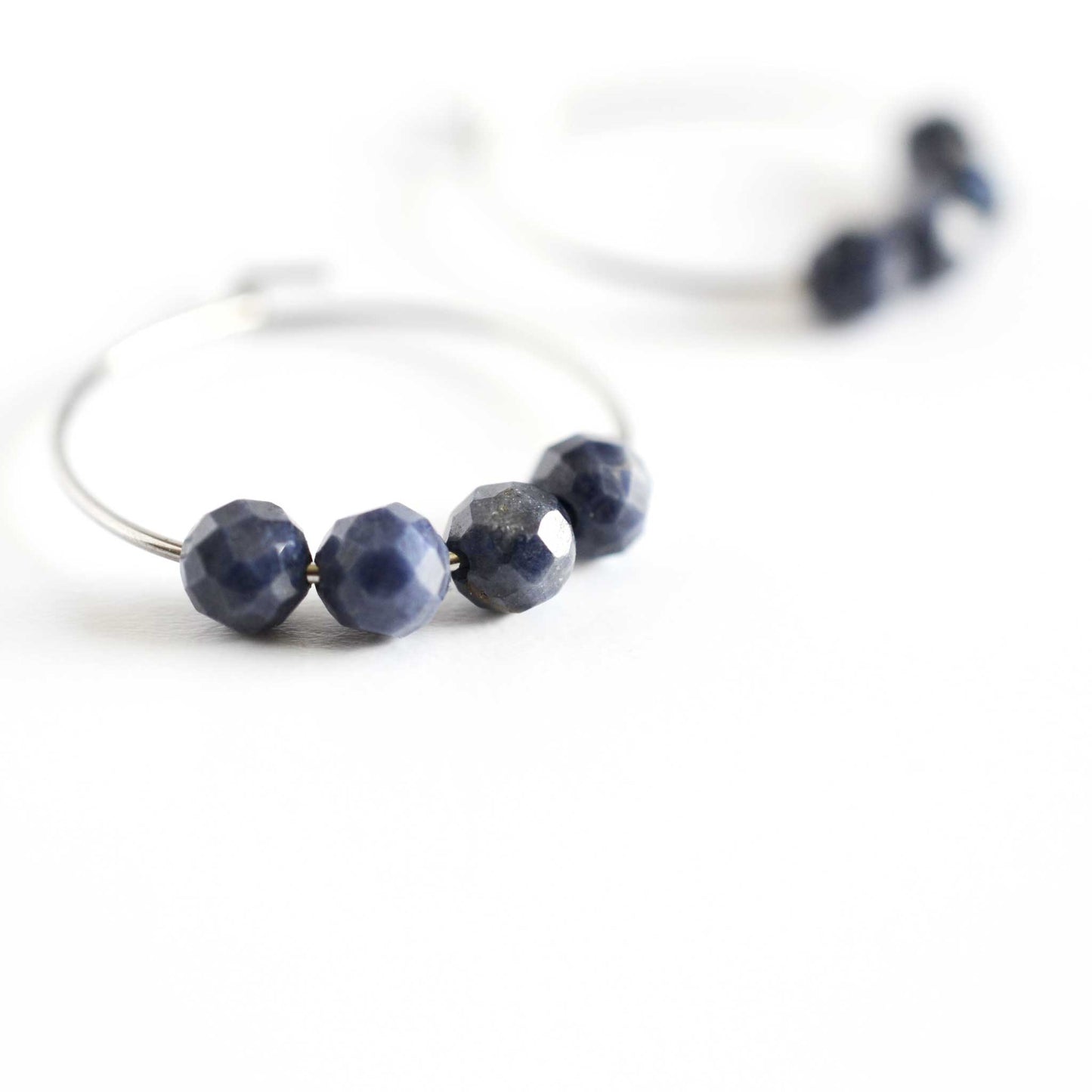 Close up of Sapphire hoop earrings with four small round faceted natural Sapphire beads
