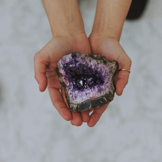 Amethyst crystal geode being held in hands