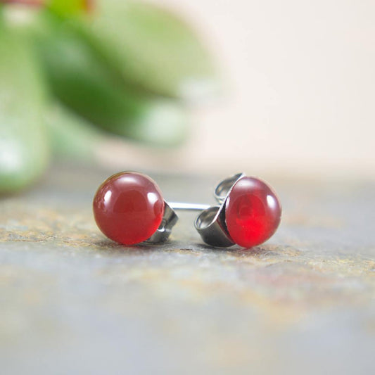 Simple red orange stone stud earrings with natural background