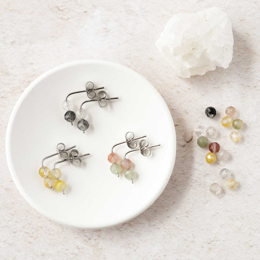 Quartz drop stud earrings in trinket dish next to crystals