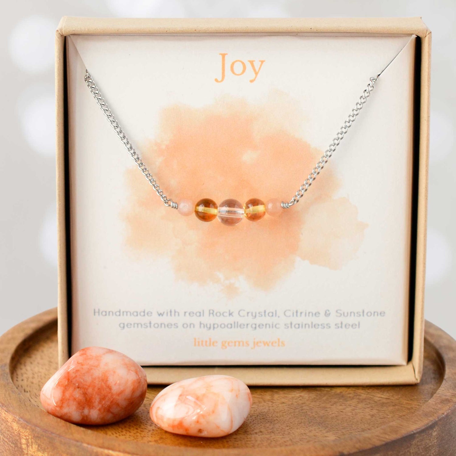 Joy gemstone necklace in eco friendly gift box on wooden coaster