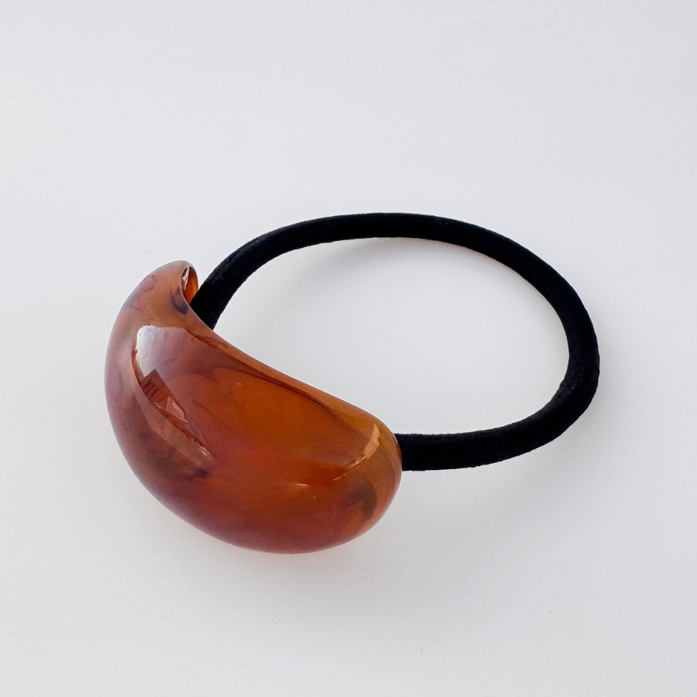Brown hair tie with a black elastic band on a white background
