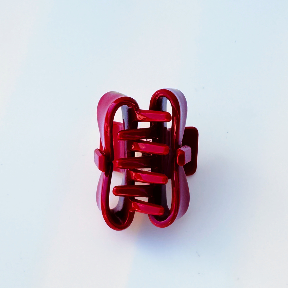 Red hair clip on a light blue background