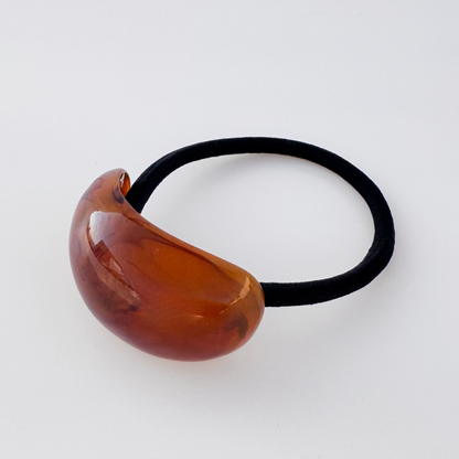 Brown hair tie with a black elastic band on a white background