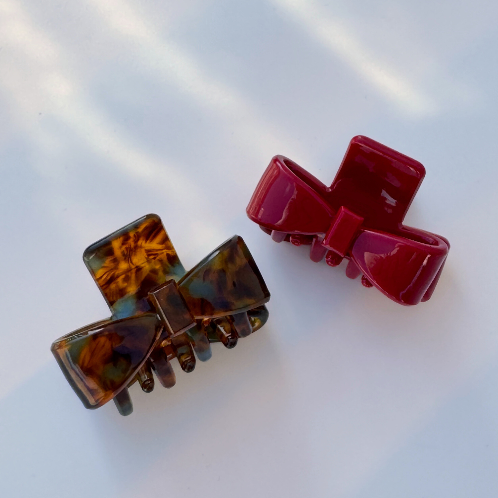 Two hair clips, one brown and one red, on a light background