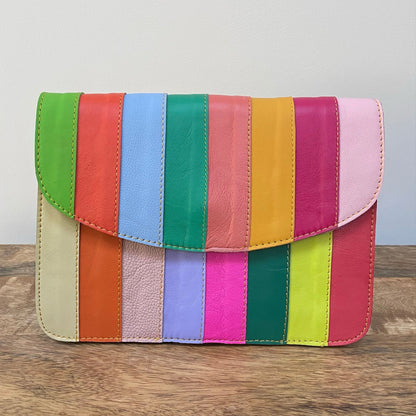 Multicolored striped purse on a wooden surface with a neutral background