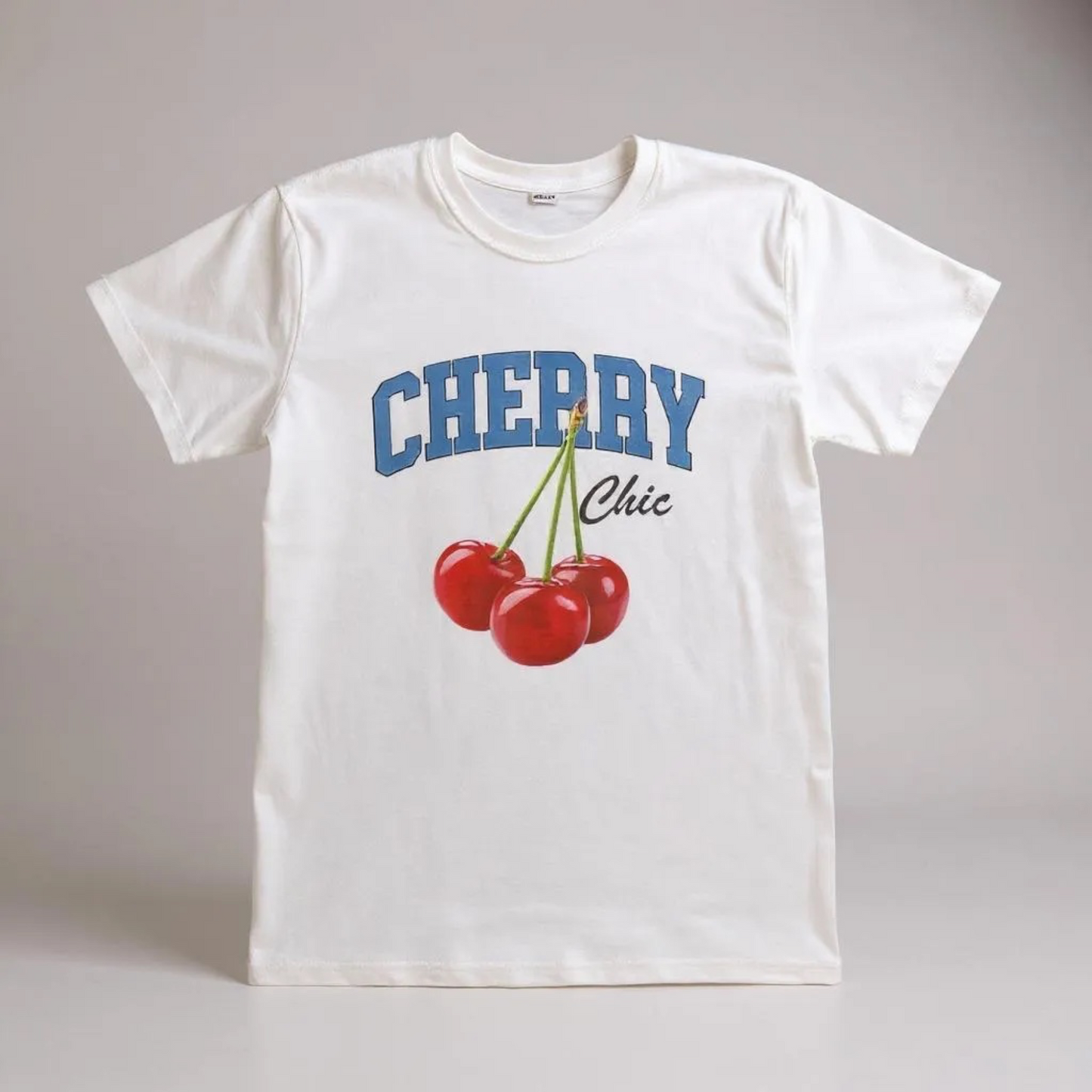 White t-shirt with 'Cherry Chic' design on a gray background