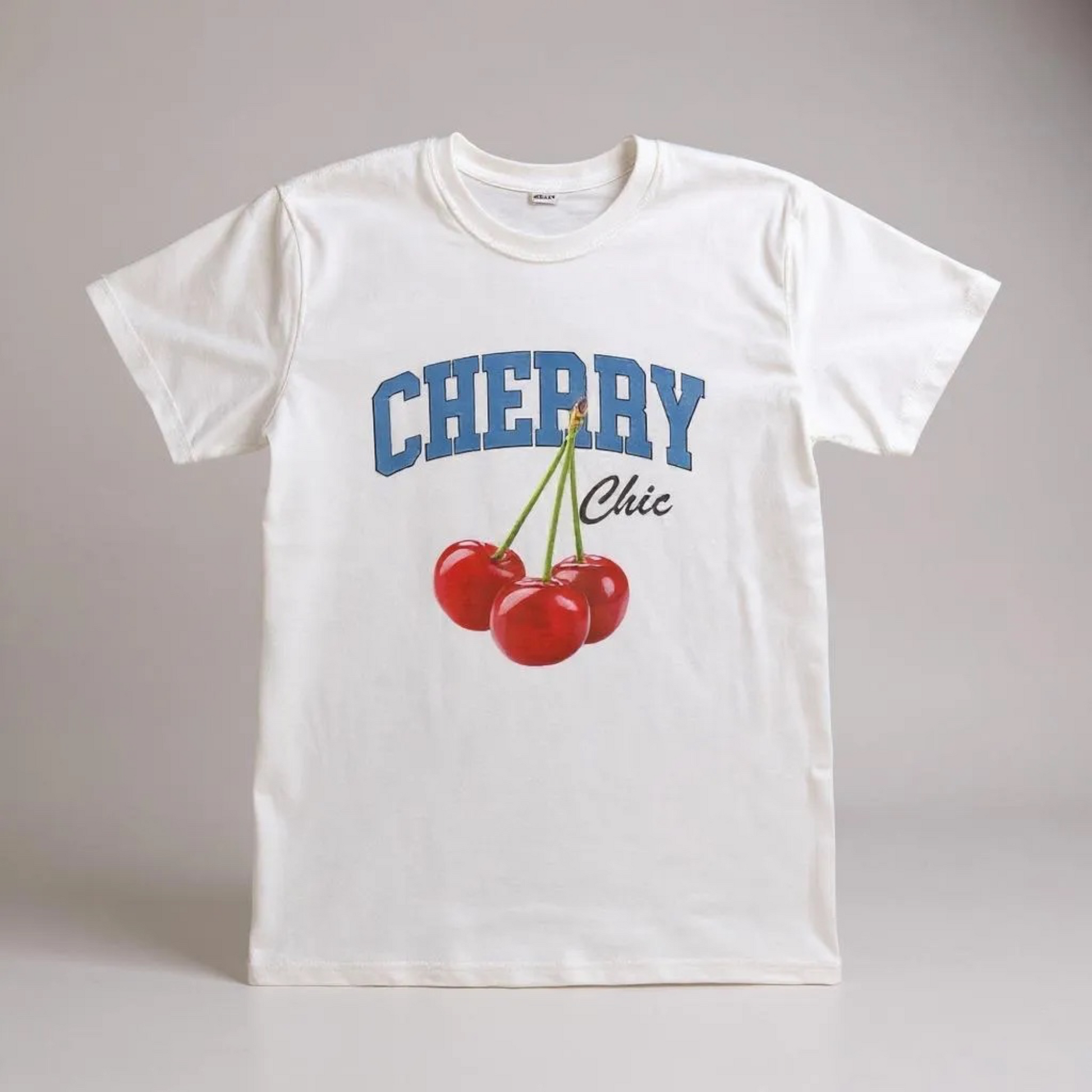 White t-shirt with 'Cherry Chic' design on a gray background