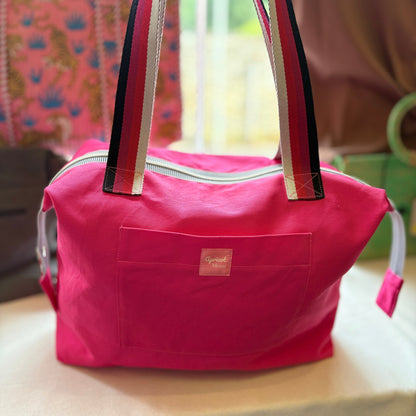 Pink bag with a visible brand logo on a blurred background