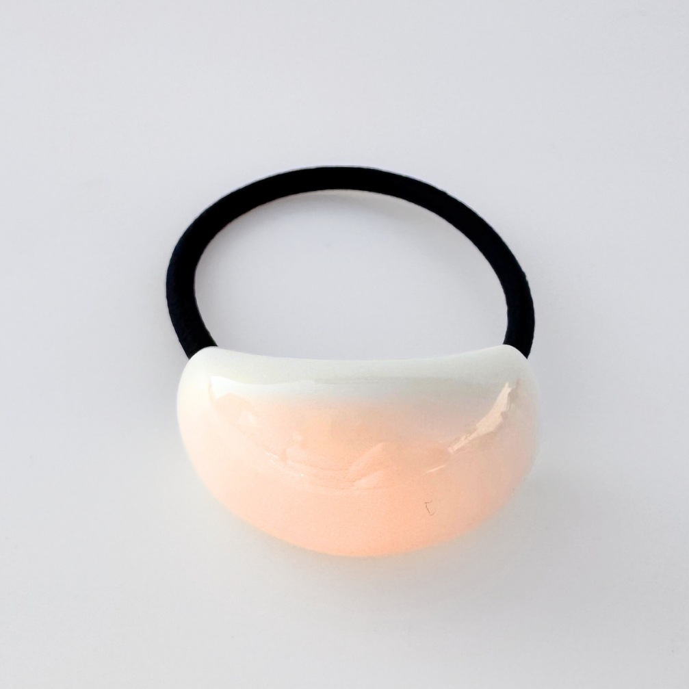 Hair tie with a gradient design on a light gray background