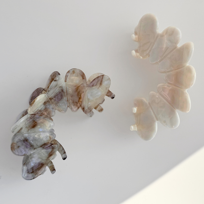 Two butterfly-shaped hair clips on a light background