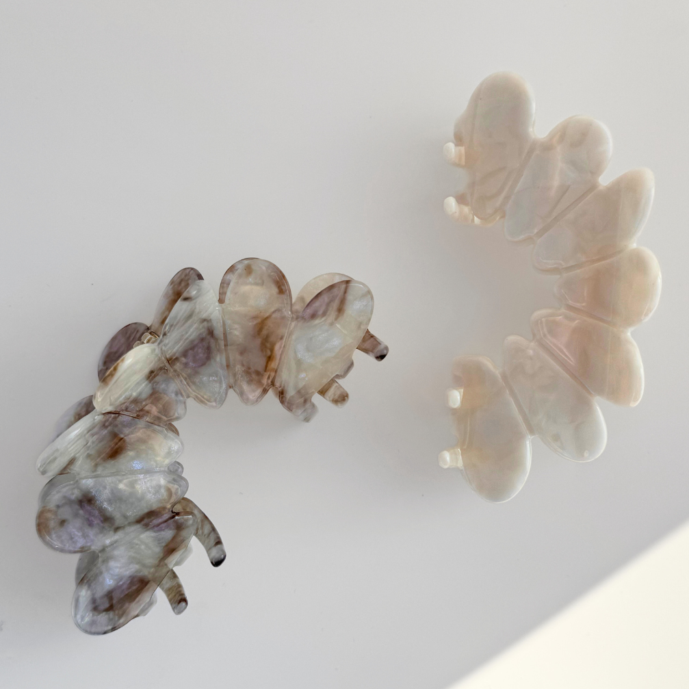 Two butterfly-shaped hair clips on a light background