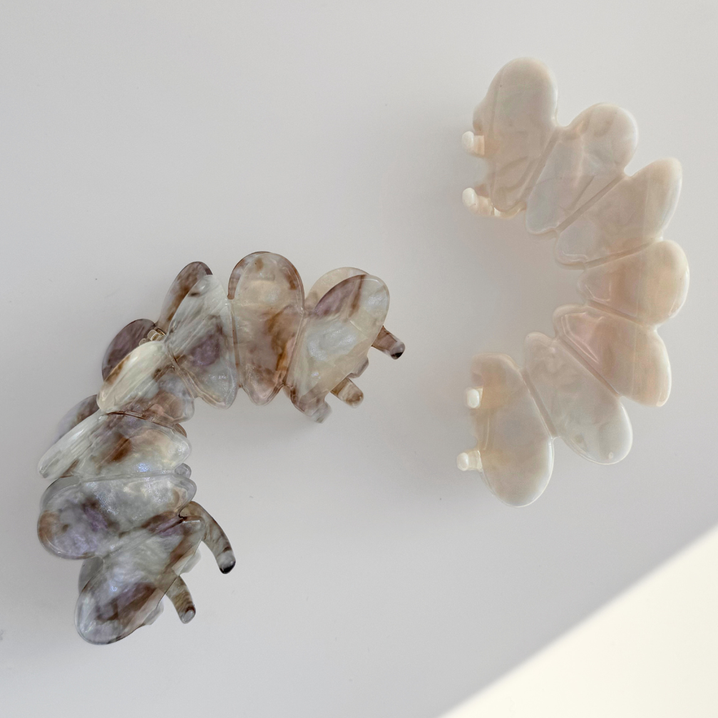 Two butterfly-shaped hair clips on a light background