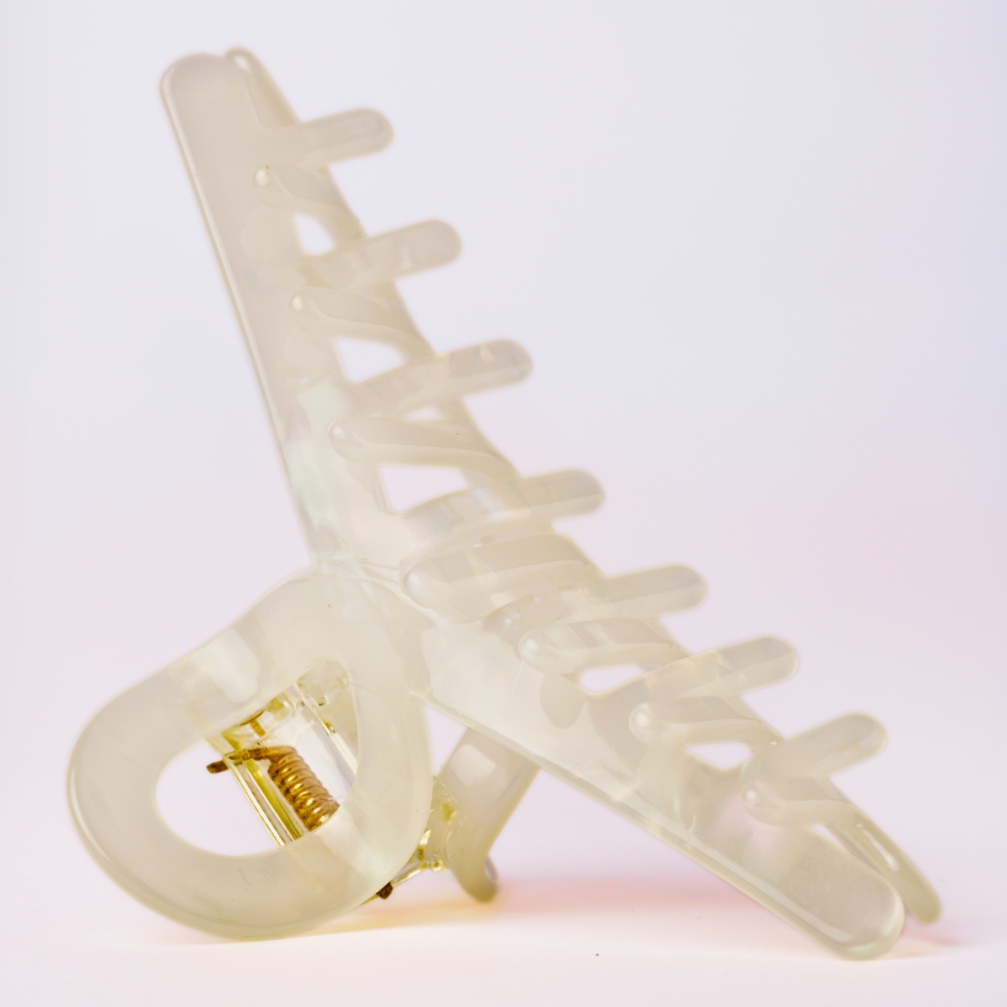Cream hair clip on a light pink background