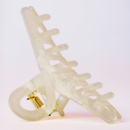 Cream hair clip on a light pink background