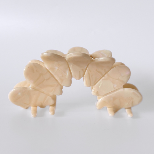 Beige hair clip with butterfly design on a white background