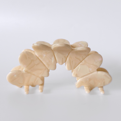 Beige hair clip with butterfly design on a white background