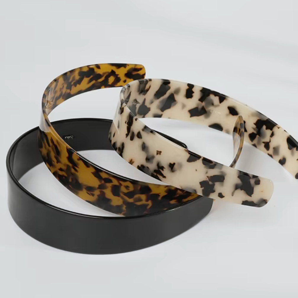 Three hairbands with leopard print, black, and beige patterns on a white background